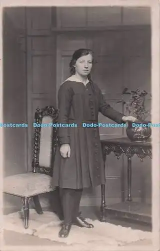 R693450 Junge Frau im langen Kleid steht am Tisch. 1917