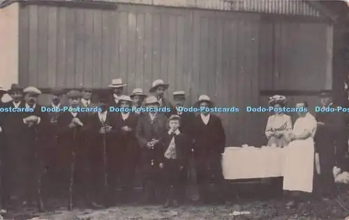 R700548 Gruppenfoto. Menschen stehen am großen Haus. Der Tisch ist gedeckt