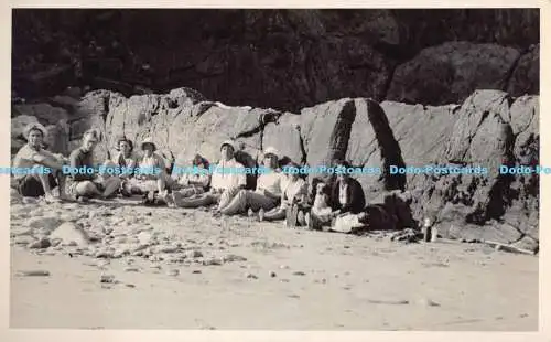 R190104 Personen. im Sand sitzen. Alte Fotografie. Postkarte