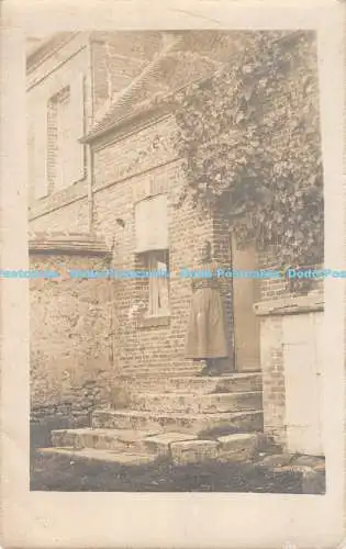 R190161 Frau. Oben auf der Treppe vorne im Haus stehend. Alte