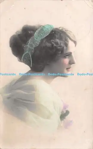 R239120 Frau mit blauem Band in Haaren und Blumen in den Händen Postkarte 1911