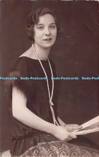 R251822 Frau im schwarzen Kleid Perlen um den Hals Portrait Postkarte 1925