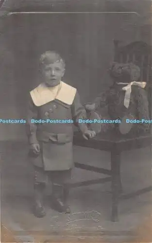 R310688 Der Junge steht am Stuhlbär auf dem Stuhl S Ashworth