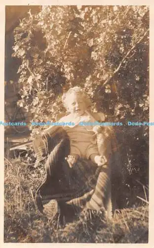 R338384 Ein kleines Kind sitzt mit 11 Monaten Kodak auf einem Stuhl auf der Wiese Russel