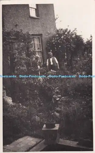 R373209 Frau und Mann stehen im Garten Postkarte