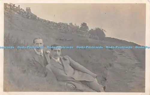 R417249 Zwei Männer sitzen im Gras Postkarte