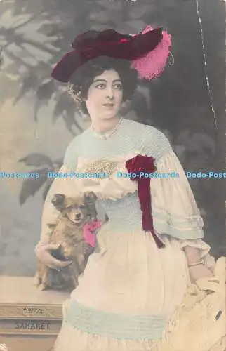 R528548 Saharetin Frau mit bunter Kleidung und Hund in den Händen 1905