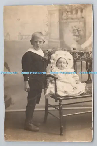 R804333 Junge und Baby Baby sitzend auf dem Stuhl