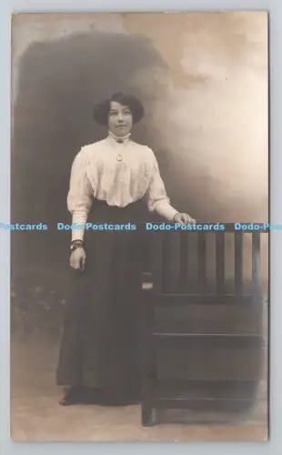 R805062 Frau steht neben Stuhl. L.A