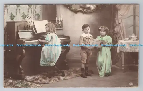 R805412 Mädchen spielt Klavier. Junge und Mädchen lesen