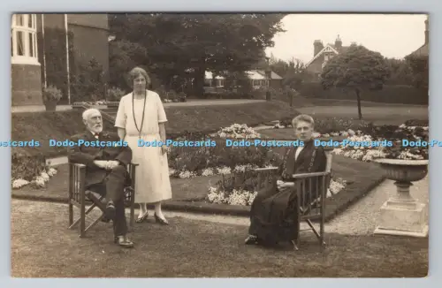R805482 Zwei Männer sitzen auf dem Stuhl. im Garten. Frau