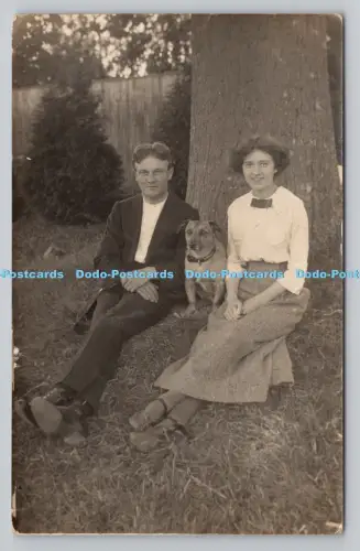 R807651 Mann und Frau sitzen unter dem Baum. Hund