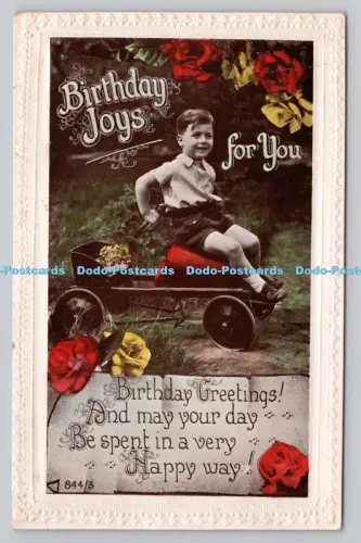 R808054 Geburtstagsfreuden für Sie. Junge sitzt auf dem Spielzeugauto. Britische Produktion Th