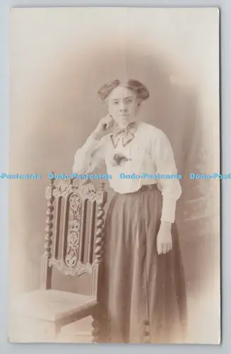 R801286 Frau steht am Stuhl Postkarte