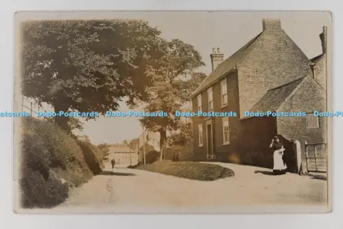 C032574 Cherry Burton East Yorkshire Frau steht neben der Home Street