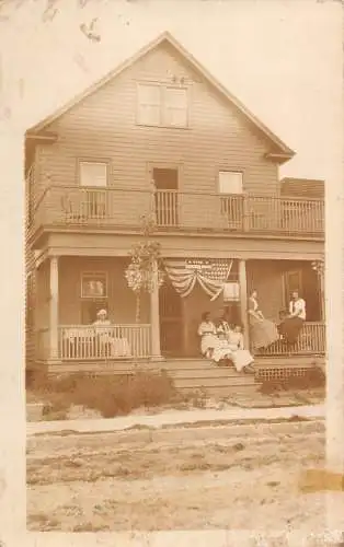 A191 US Unidentified RPPC Sepia The Bremen House Family Flag Girls Postkarte