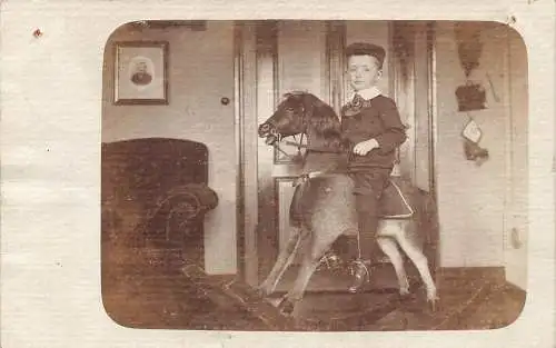 A093 Echt Foto 1906 Kleiner Junge auf balancierendem Pferd Spielzeug im Haus Vintage Postkarte
