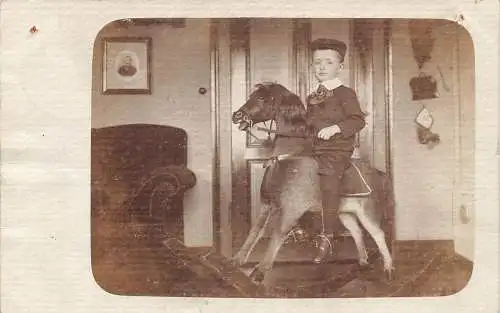 A093 Echt Foto 1906 Kleiner Junge auf balancierendem Pferd Spielzeug im Haus Vintage Postkarte