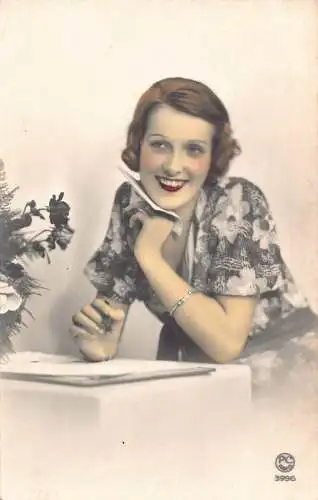 Frau mit Blumenkleid lächelt und hält Brief Vintage Postkarte