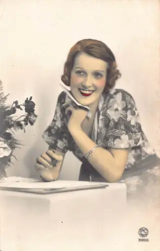 Frau mit Blumenkleid lächelt und hält Brief Vintage Postkarte