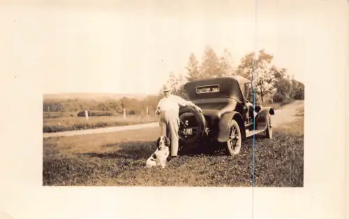 L547 Buick Roadster Mann posiert neben Auto mit Hund RPPC Postkarte