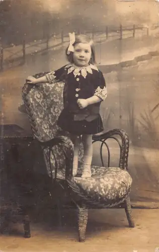 A881 Echt Foto kleines süßes Mädchen Band im Haar sitzend auf Stuhl Postkarte