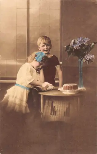 B191 Fotomontage Mädchen und Junge umarmen Kuchen Blumen in Vase Vintage Postkarte