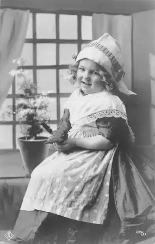 B194 Fotomontage 1908 Mädchen in Schürze in Küche hält Spielzeug Vintage Postkarte