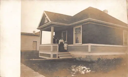 L040 Familie posiert vor dem Haus Echtfoto Vintage Postkarte