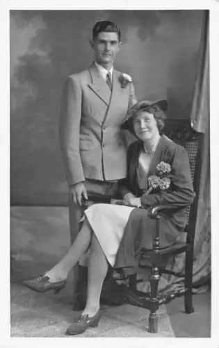 Echte Foto Liebhaber posieren elegant gekleidete Frau Nelke Blume Vintage Postkarte