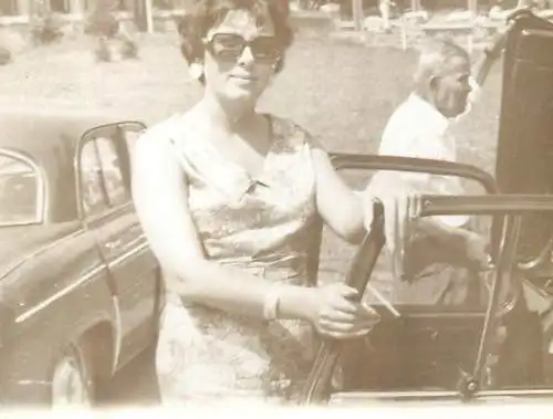Anonymous persons woman posing near car