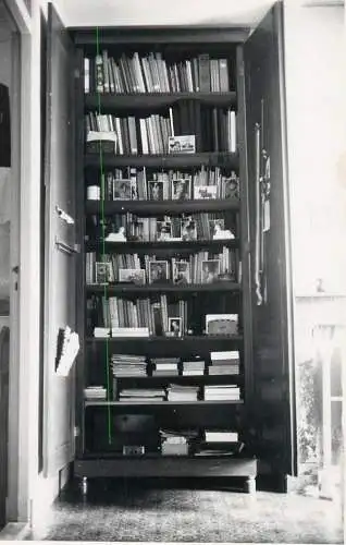Photographic postcard cabinet interior with books and souvenirs