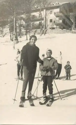 Real photo mother and child skiing on slope
