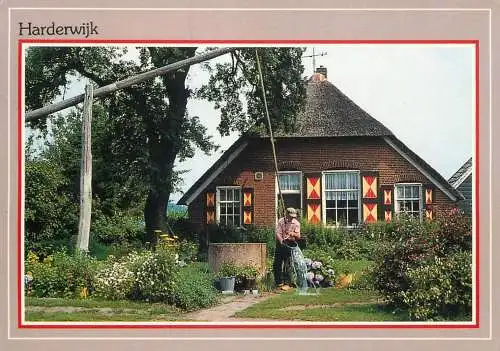 Netherlands Harderwijk typical dutch house and man taking water from well