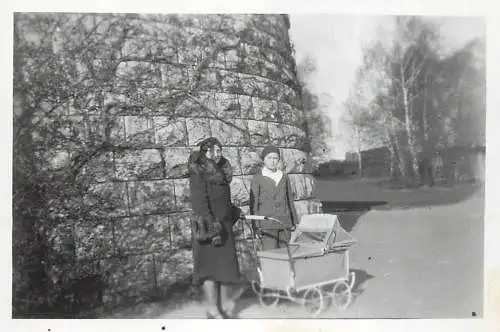 Anonymous persons with baby cart photo