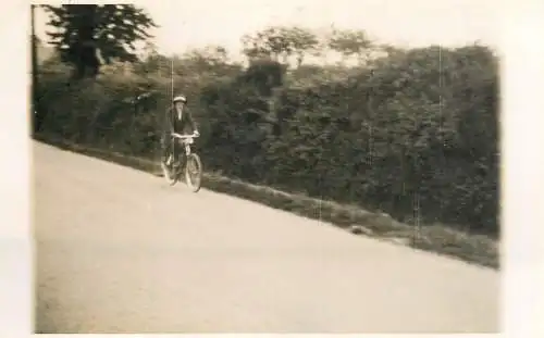 Real photo postcard place to identify lady on bicycle