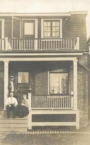 Photo postcard family outside of house