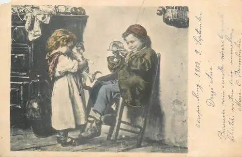 Postcard photograph of children of playing with a cat 1902