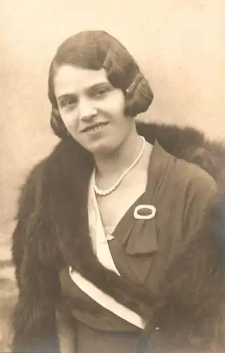 Postcard photograph of an elegant woman in fur and pearsl smile 1934 Europe