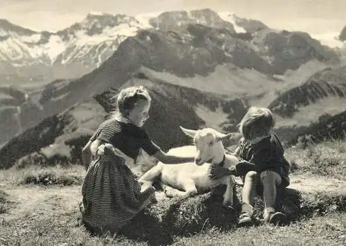 Children types boy and girl with goat picturesque mountain scenery photo W. Studer