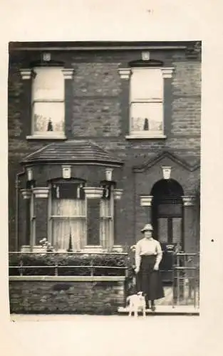 Photo postcard British social history woman and dog pet in front of the house