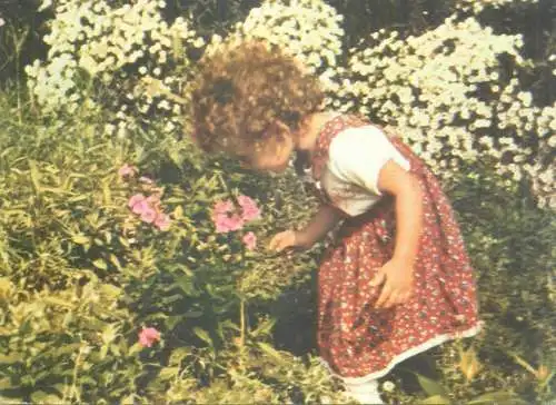 Postcard young girl picking flowers in garden