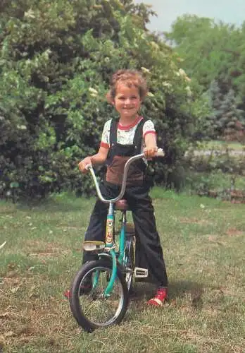 Postcard young boy riding a bike