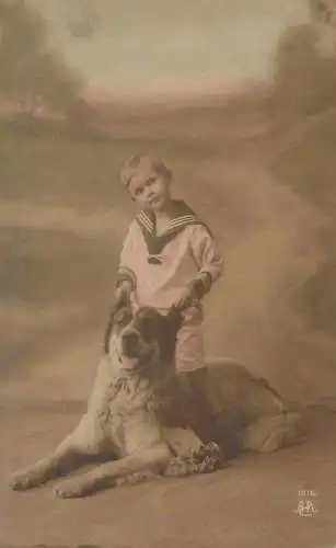 Postcard young boy wearing sailor costume playing with dog