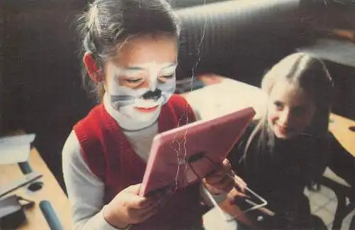 Postcard face-painted little girl looking in the mirror