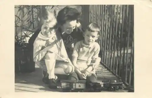 mother and her children playing with toy train outdoor detail view Postcard