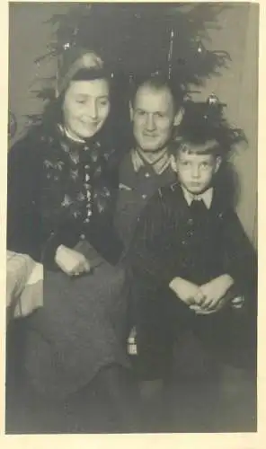 Postcard parents and young boy family group photo next to Christmas tree