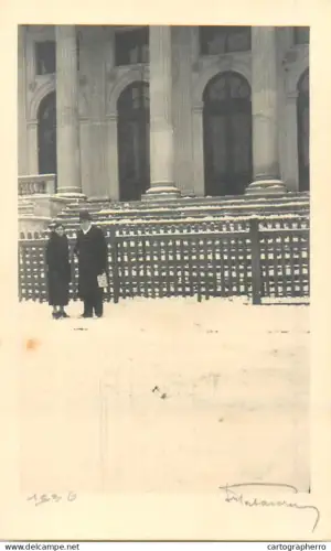 Anonymous persons in front of neoclassical building with large columns and arches during a snowy day Romania 1936