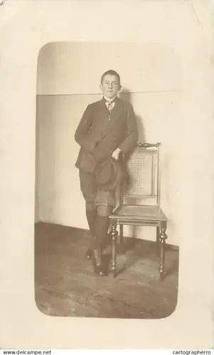 A5846 Anonymous persons vintage souvenir photographic postcard young man posing near chair
