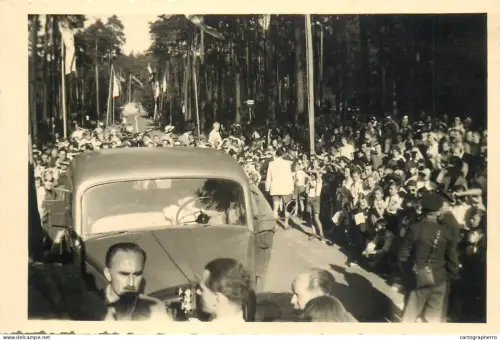A5813 arrival of an important figure event large crowd road lined with trees and flags vintage car